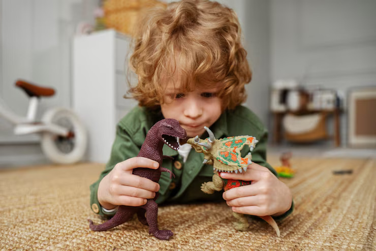 boy playing with 2 dinosaur toys